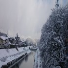 Traditional Asian pavilions in snowy landscape with calm river