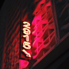 Night Cityscape: Close-Up View of Illuminated Skyscrapers in Red Tones