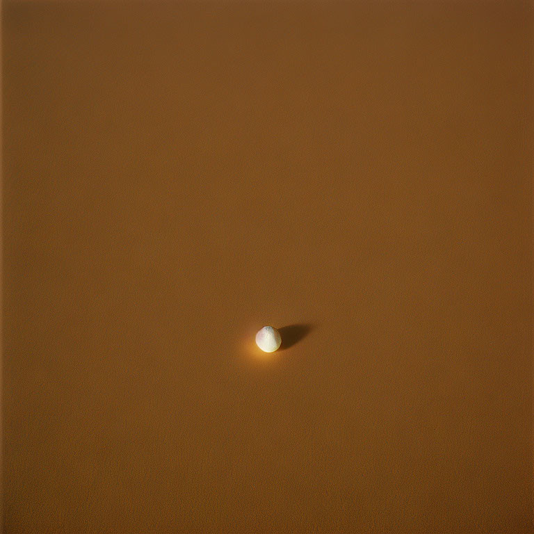 Tennis Ball on Smooth Brown Surface with Soft Shadow