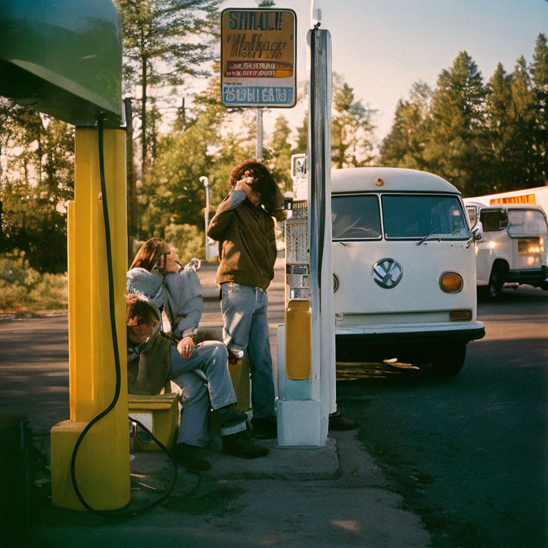 Youth relaxing at vintage gas station with VW van in forest setting