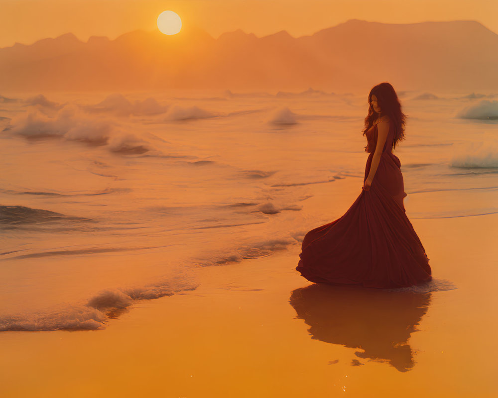 Silhouette of woman in flowing dress on beach at sunset