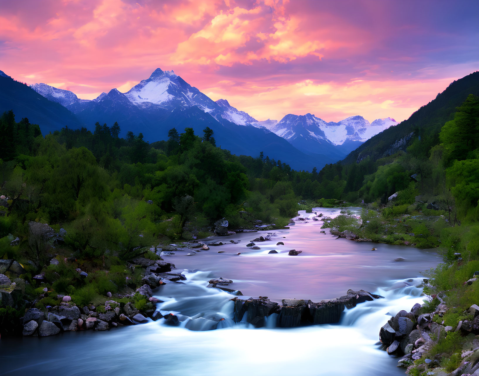 Snow-capped mountains under a pink and purple sunset sky by a serene river