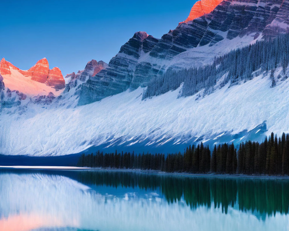 Majestic snow-covered mountain peaks reflecting in calm blue lake at dawn or dusk