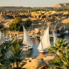 Sunlit Mediterranean harbor with sailboats and orange rooftops