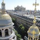 Ornate European buildings with golden domes and tree-lined street