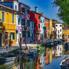 Vibrant canal scene with colorful buildings, moored boats, and lush trees