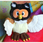 Colorful Owl Figurine with Multicolored Eyes and Black Helmet on Soft Hues Backdrop