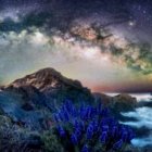 Colorful surreal digital artwork of starry skies over mountainous landscape