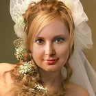 Elaborate golden headgear portrait with white veil and floral decorations