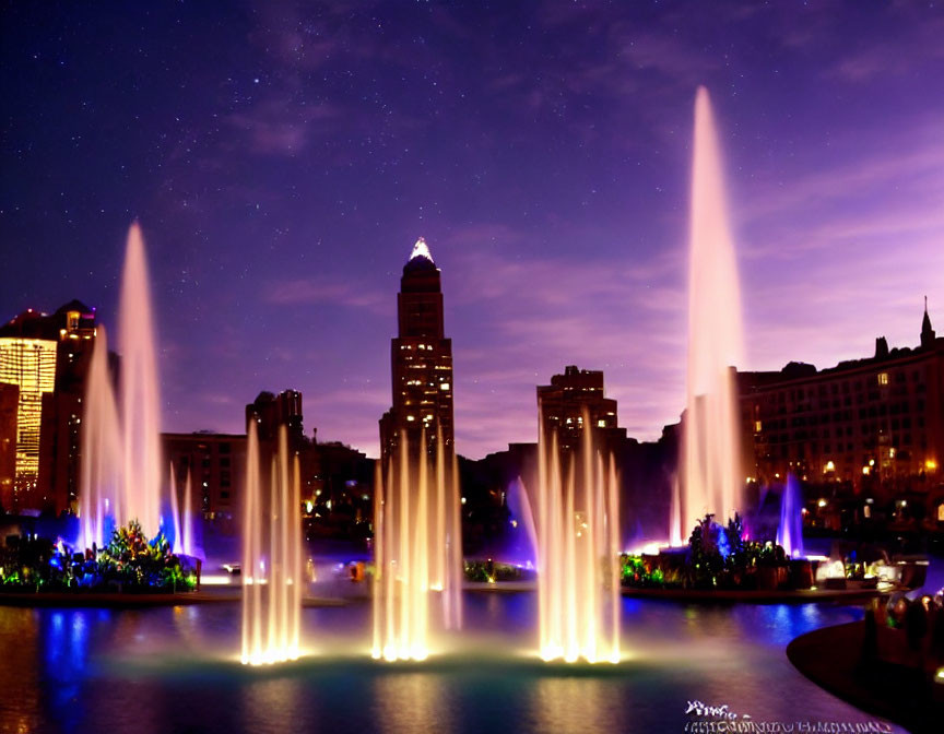 Nighttime cityscape with lit fountains, illuminated buildings, and starry sky