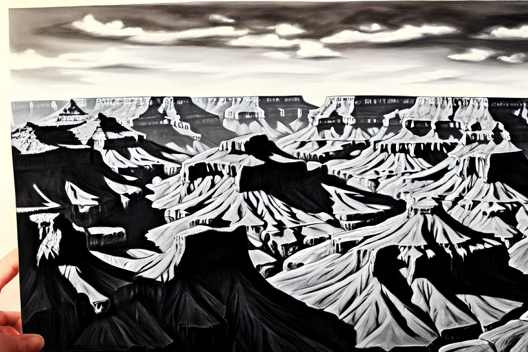 Monochrome illustration of hand holding canyon against cloudy sky