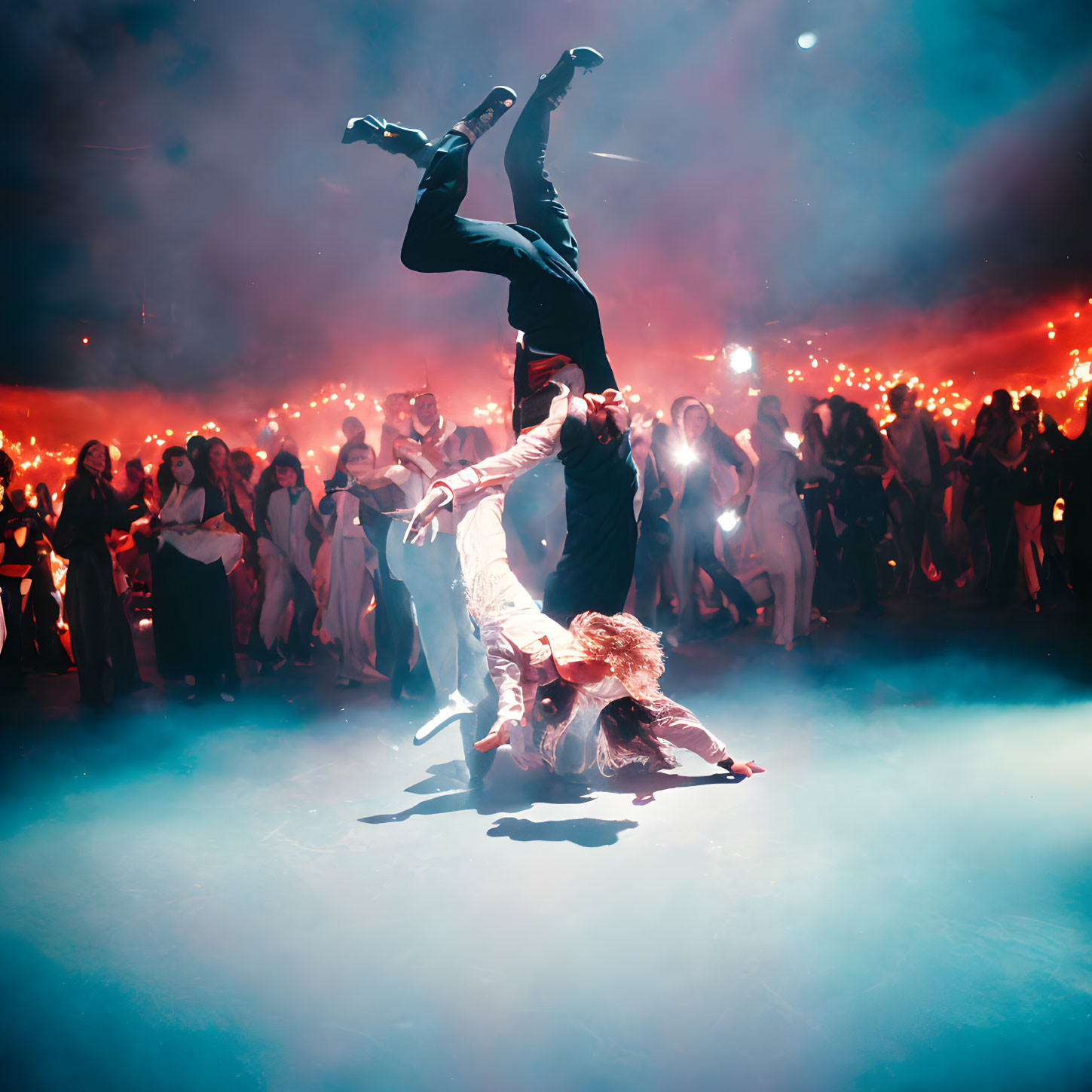 Acrobatic dance performance on foggy stage with red lights