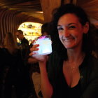 Woman in dark cave holding large blue crystal surrounded by glowing crystals