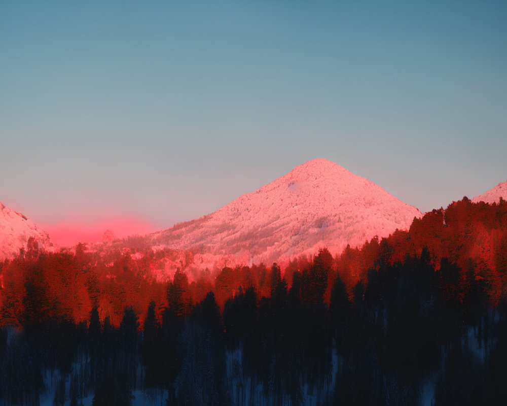 Snow-covered mountains and forest under vibrant sunset sky