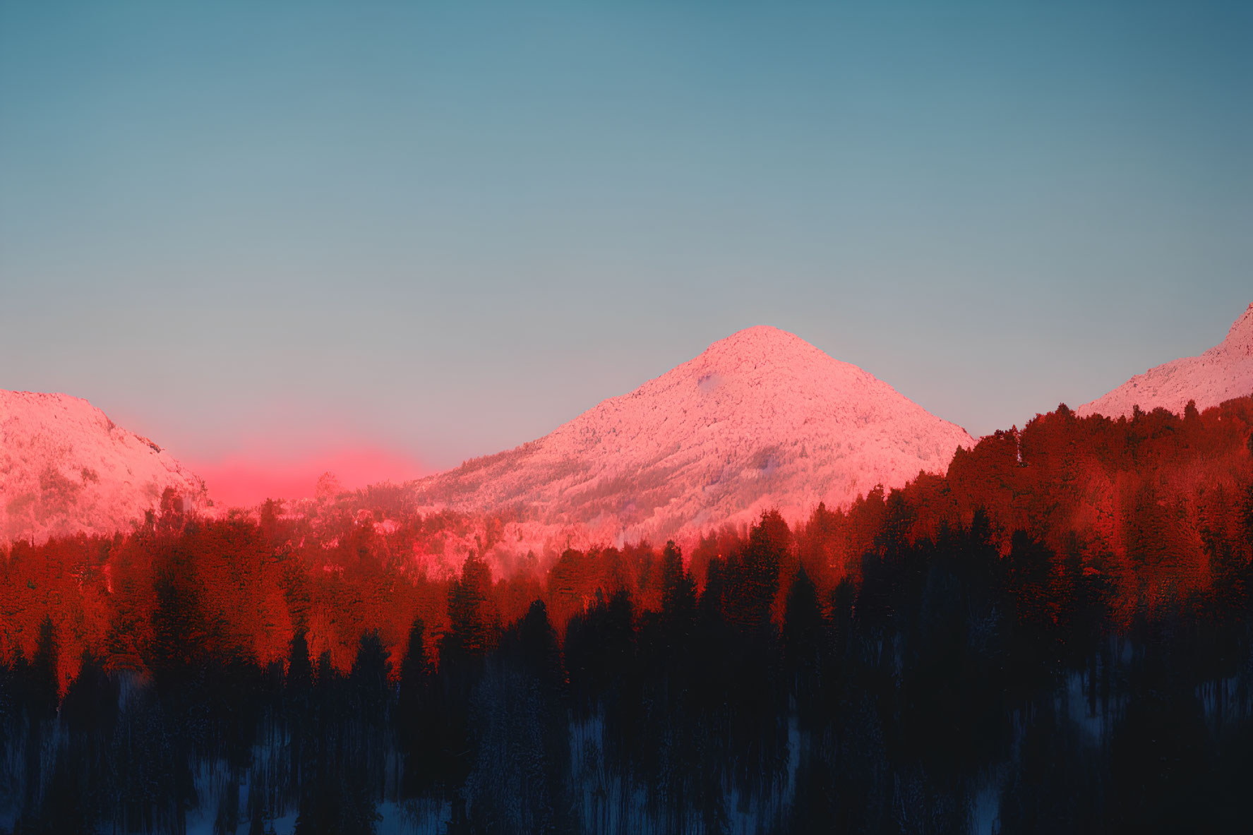 Snow-covered mountains and forest under vibrant sunset sky