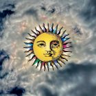 Colorful celestial sun face in serene expression among vibrant clouds.