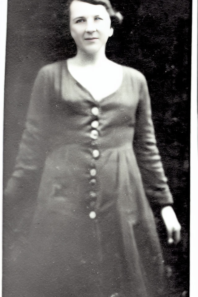 Smiling woman in vintage black-and-white dress.