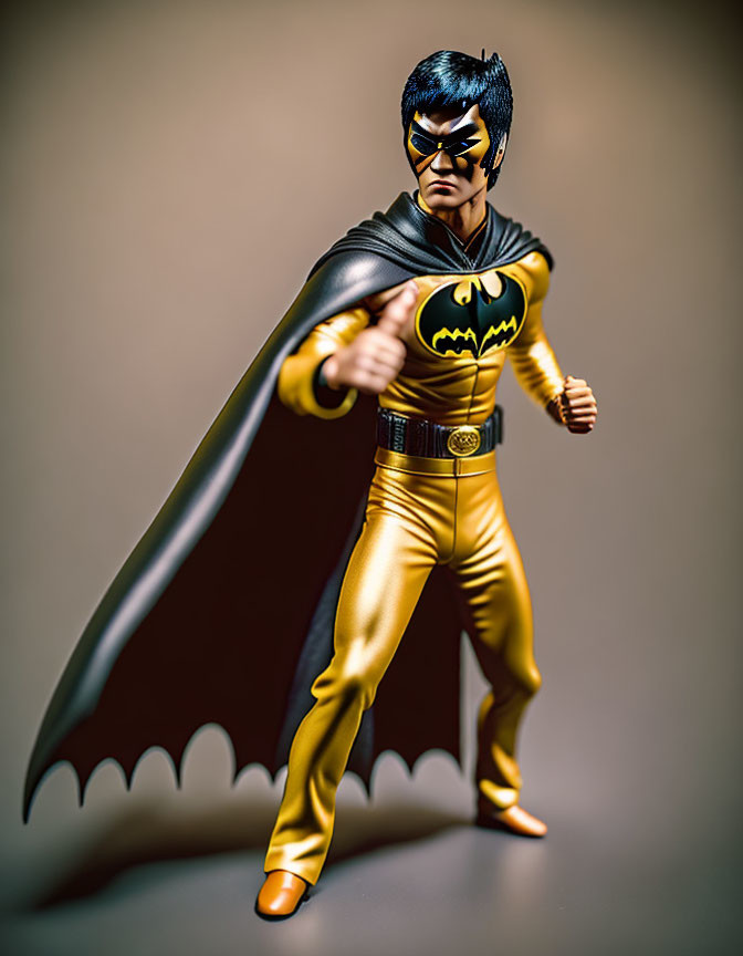 Superhero figure in yellow and black costume with cape and mask