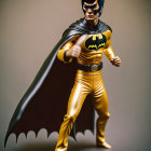 Superhero figure in yellow and black costume with cape and mask