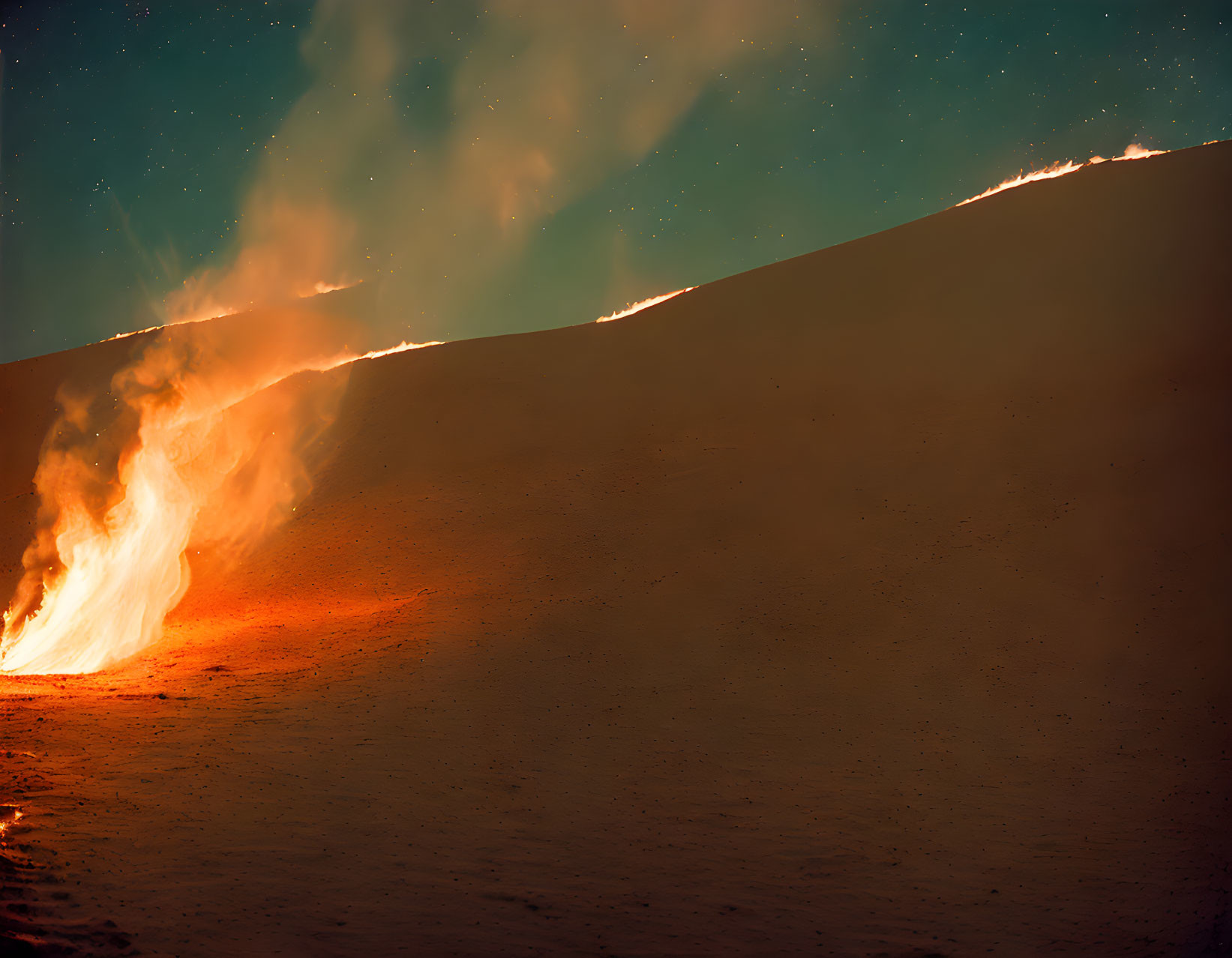 Dusk wildfire engulfs hillside with raging flames