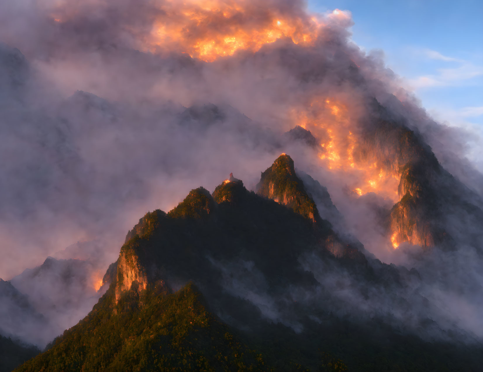 Misty mountain peaks in fiery sunset or sunrise light