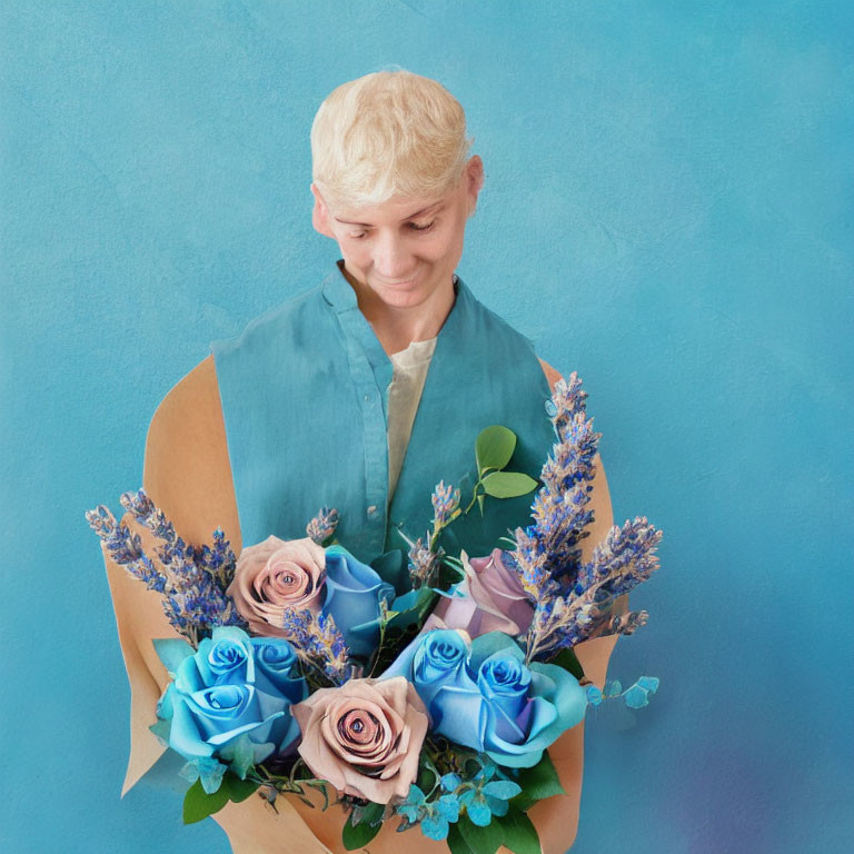 Blond person smiling with bouquet of blue and pink roses on blue background