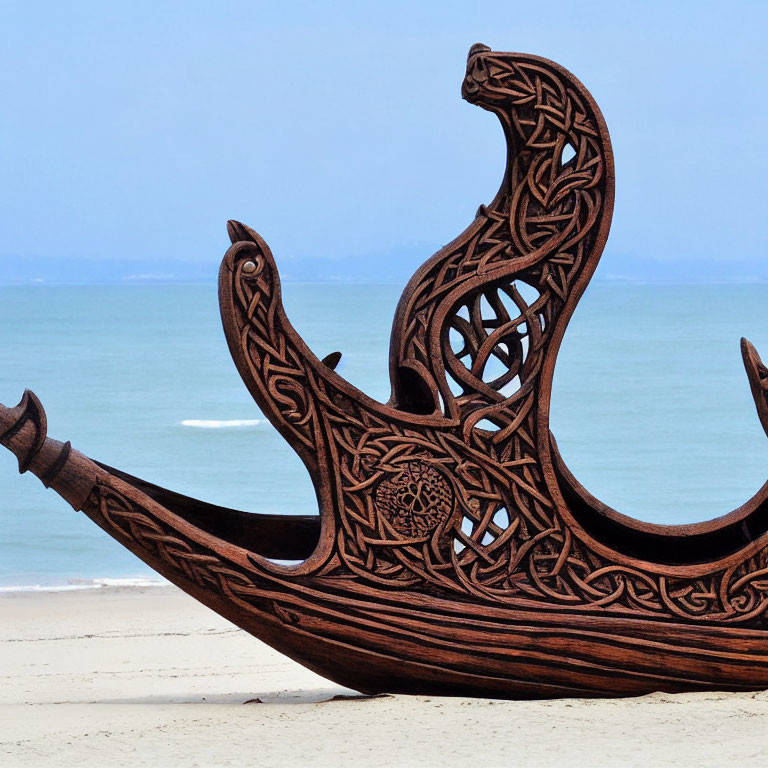 Wooden Ship Sculpture with Celtic Designs on Sandy Beach