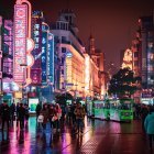 Neon-lit scene with traditional boats and Chinese lanterns on water