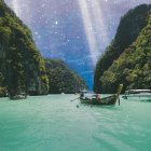 Ethereal landscape with serene lake, wooden boats, lush trees, mystical sky