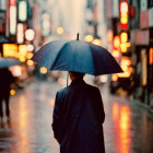Person standing on wet city street at night with blue umbrella and glowing lights.