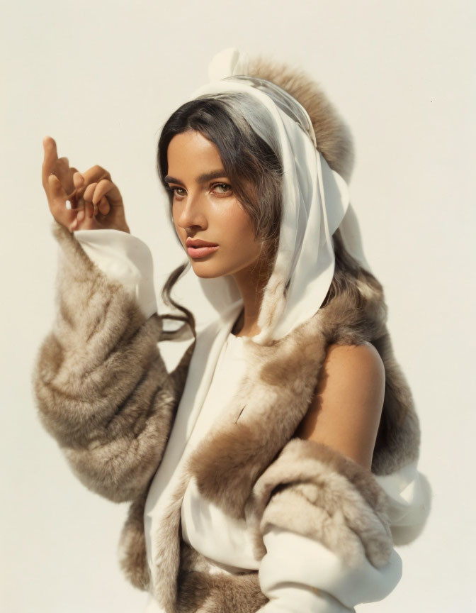 Woman posing elegantly in fur hooded garment under sunlight