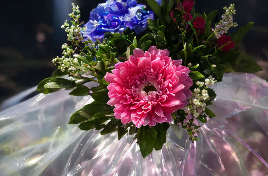 Colorful bouquet featuring pink, blue, and white flowers in clear wrapping