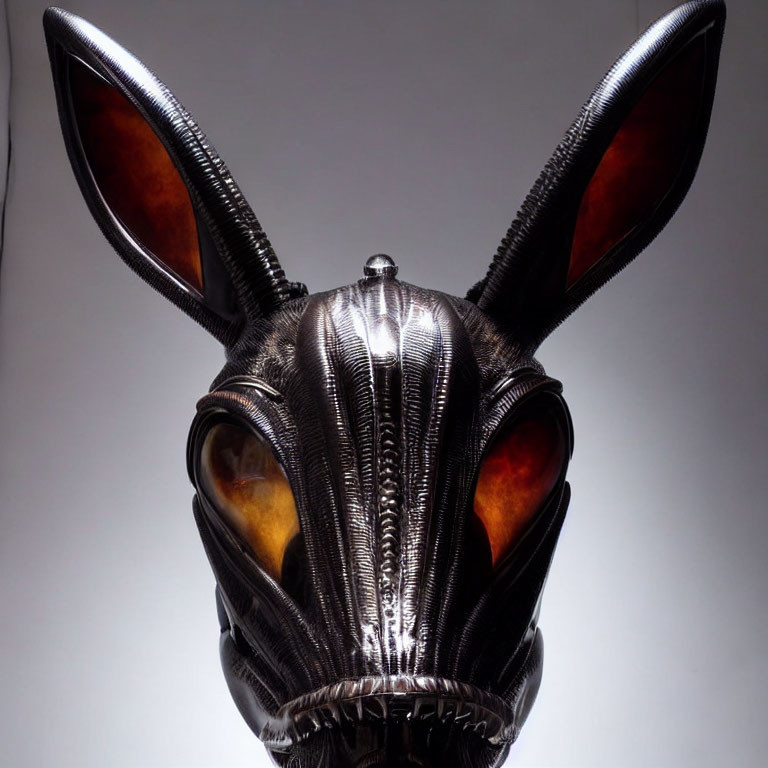 Stylized black and silver mask with pointed ears and amber eye lenses