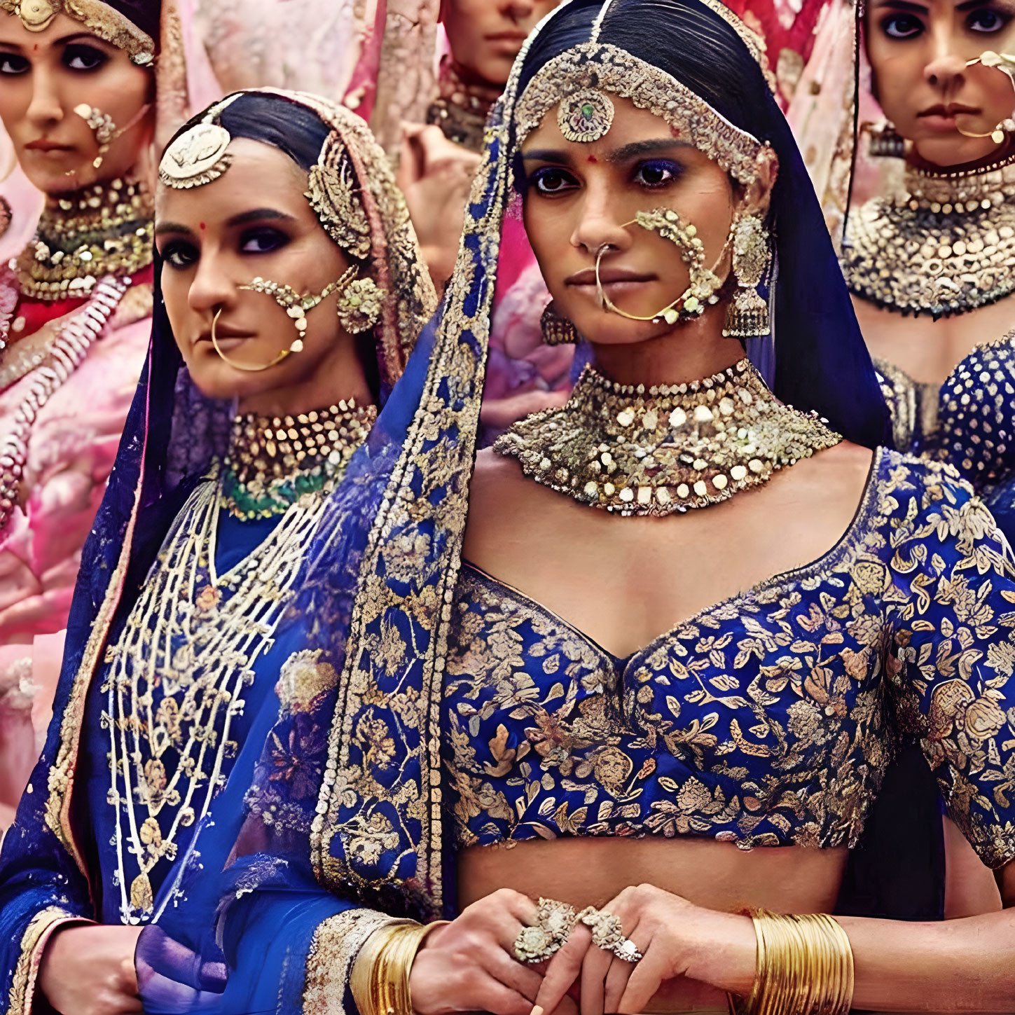 Traditional Indian bridal attire: Women in blue and gold with elaborate jewelry