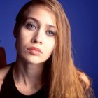 Red-haired woman portrait with blue eyes on blue background