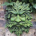 Green leafy face sculpture on textured grey background