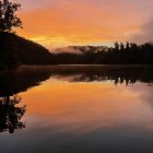 Serene Sunset Landscape with Reflective Lake and Mountains