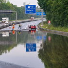 Rainy day scene with wet road, cars, road signs, and water drops on window