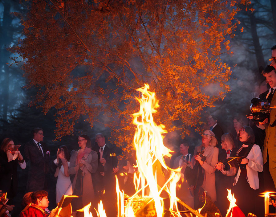 Group of People Around Large Bonfire at Dusk