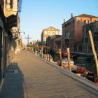 Historic buildings line serene Venetian canal at dusk